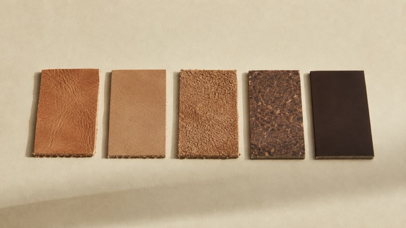 Five leather samples in a row: full-grain, top-grain, split suede, reconstituted leather fibre and a synthetic sheet, cut edges showing